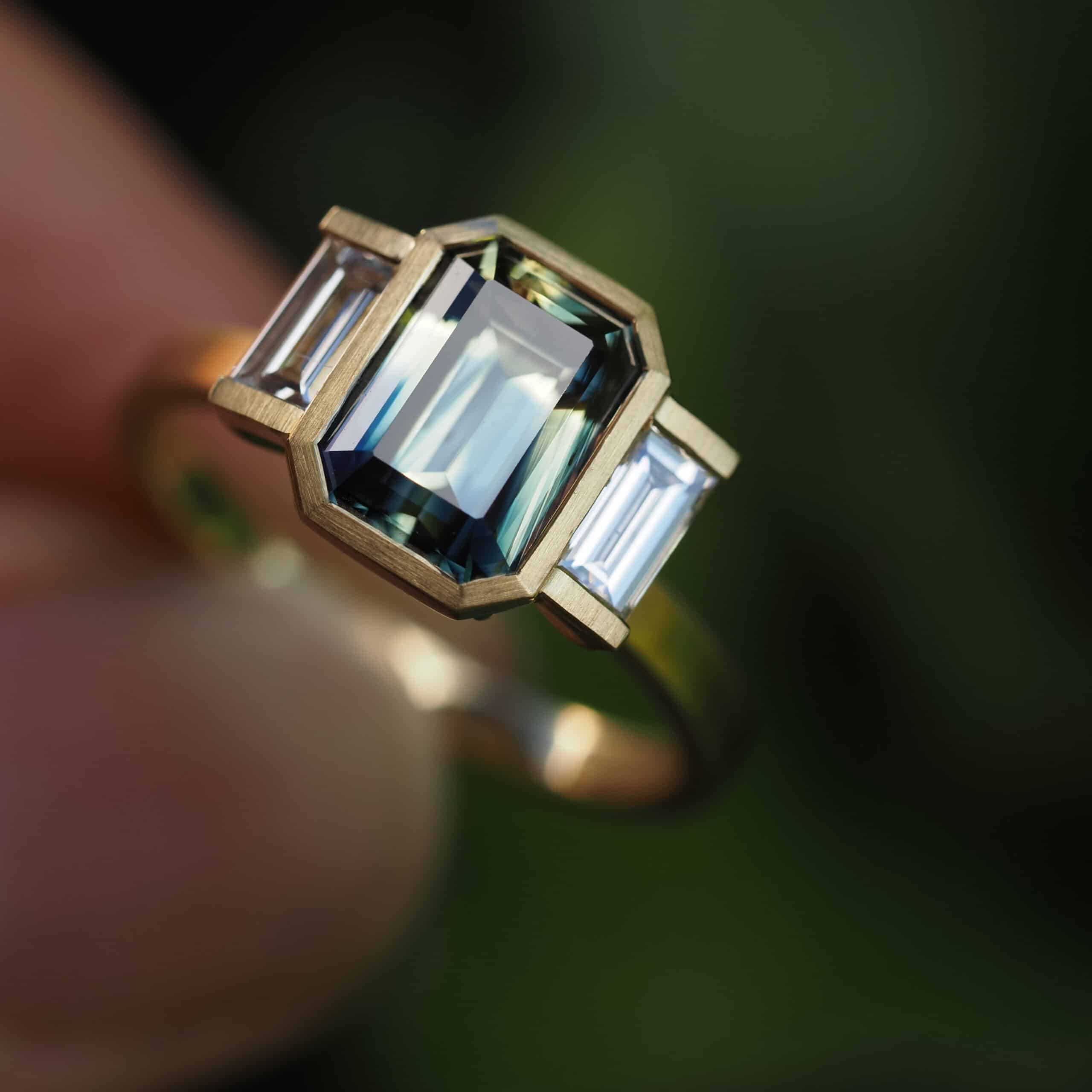 Art Dec engagement ring with emerald cut Australian parti sapphire and baguette diamonds